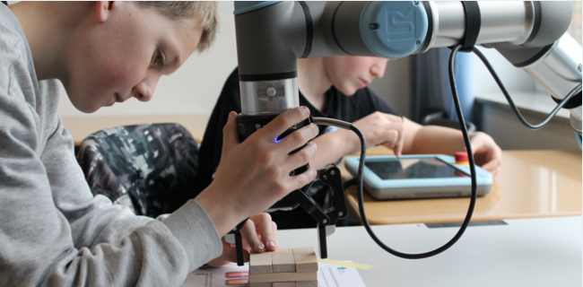 ein Junge bedient einen Roboter