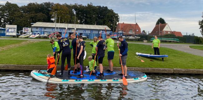mehrere Wassersportler auf einem XXL-SUP