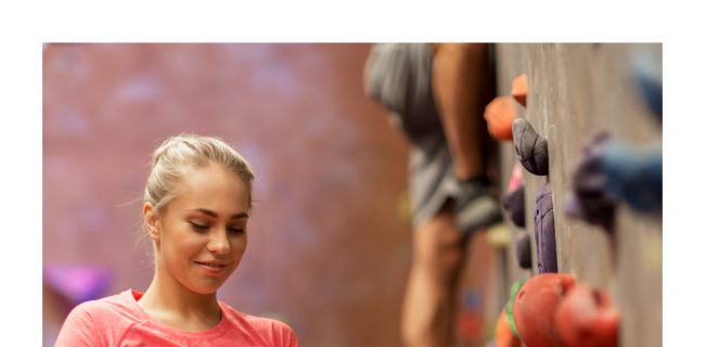 Ein Mädchen vor einer Kletterwand