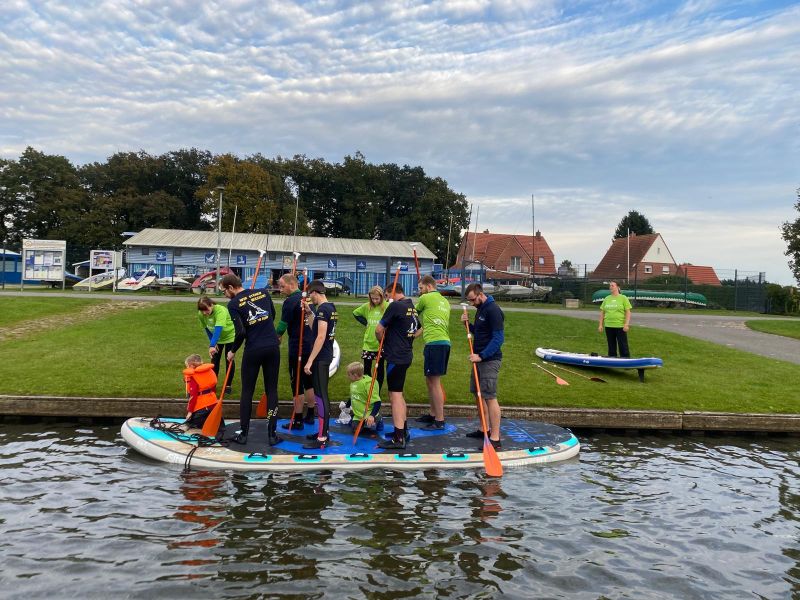 mehrere Wassersportler auf einem XXL-SUP