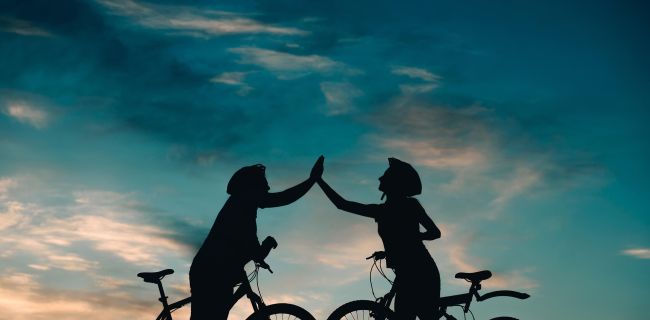 zwei Radfahrer begrüßen sich