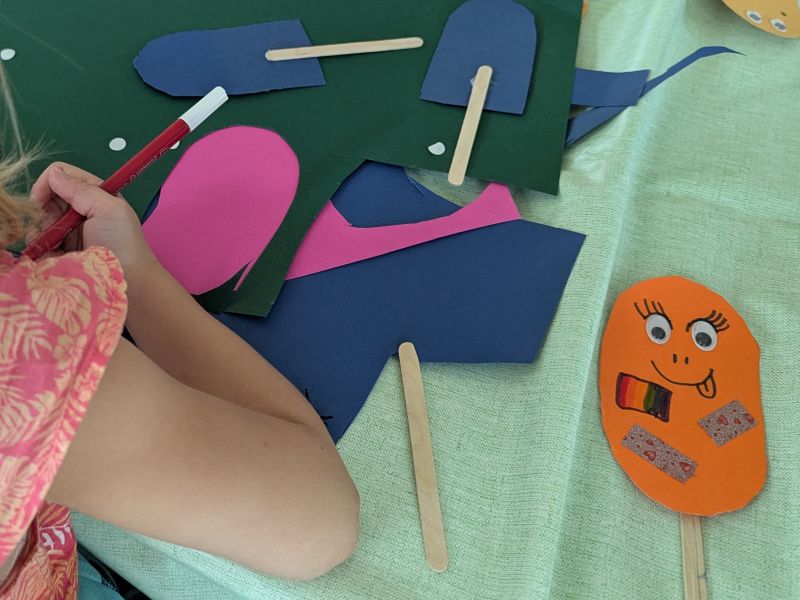Kind bastelt aus Pappe lustiges Eis am Stiel 